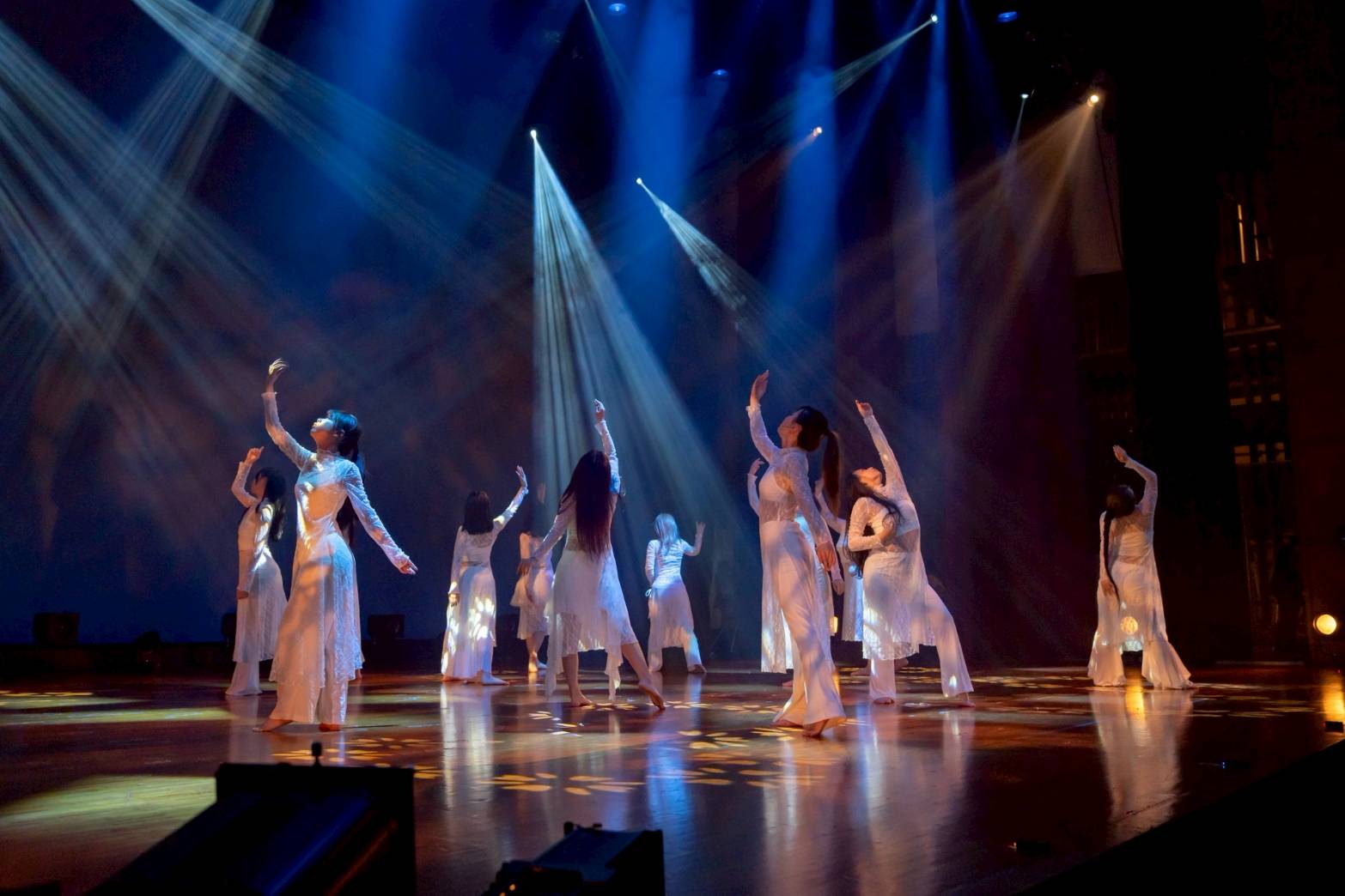 発表会のステージで、白い衣装でスポットライトを浴びて踊るDance Studio Avenirの生徒たち
